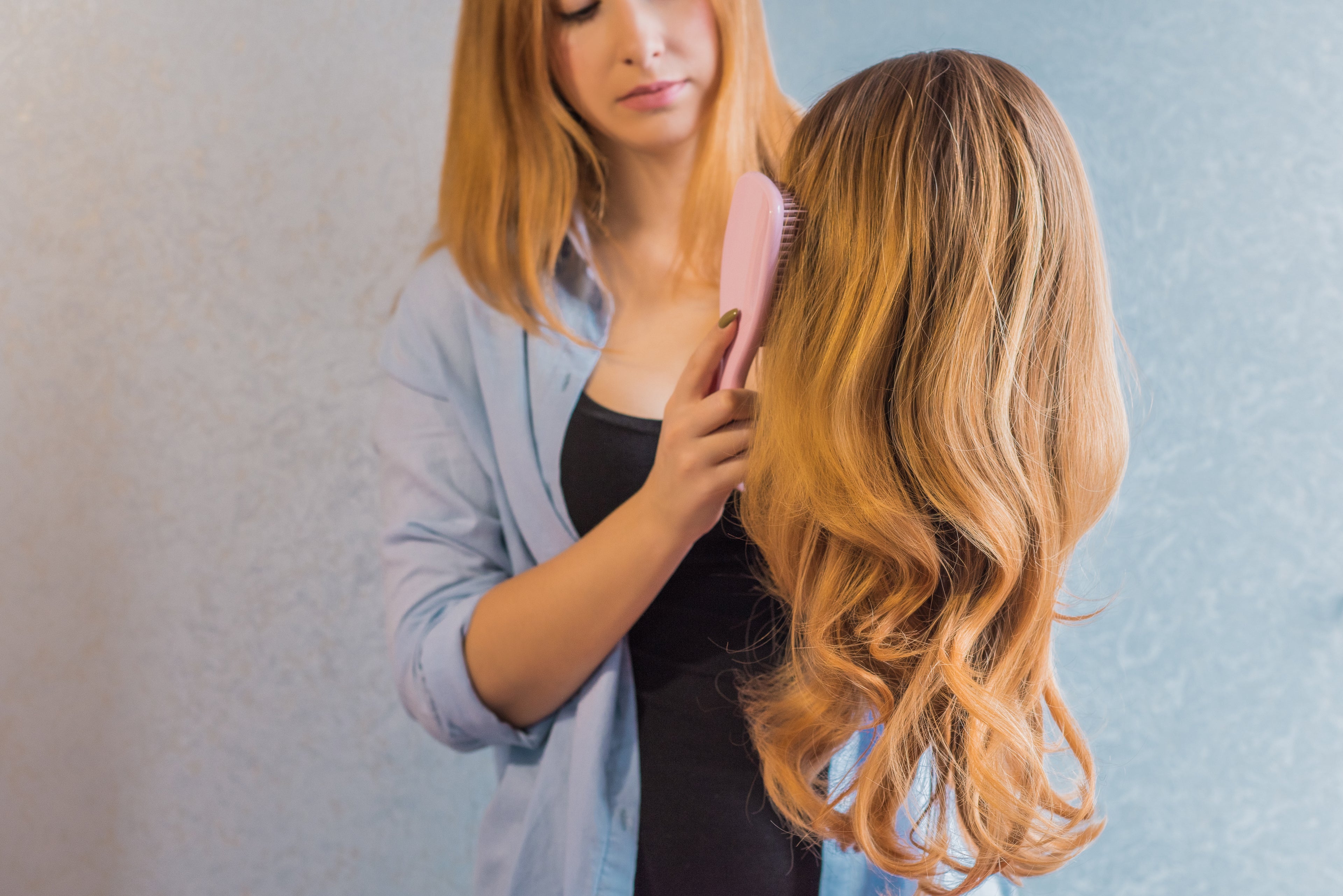 Woman brushing a blonde wig